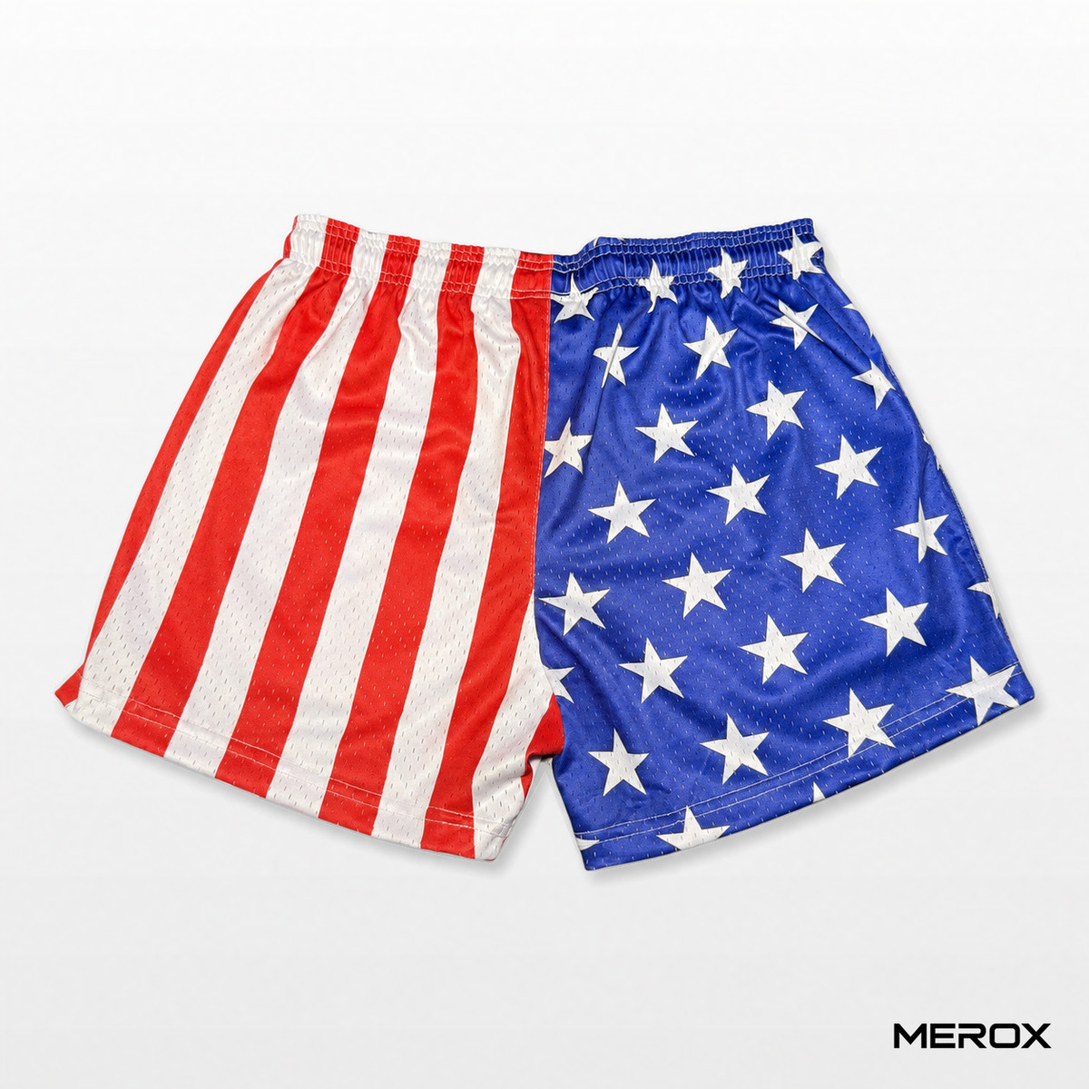 Back view of MEROX USA American flag mesh shorts showing red-and-white vertical stripes, blue fabric with white stars and an elastic waistband.