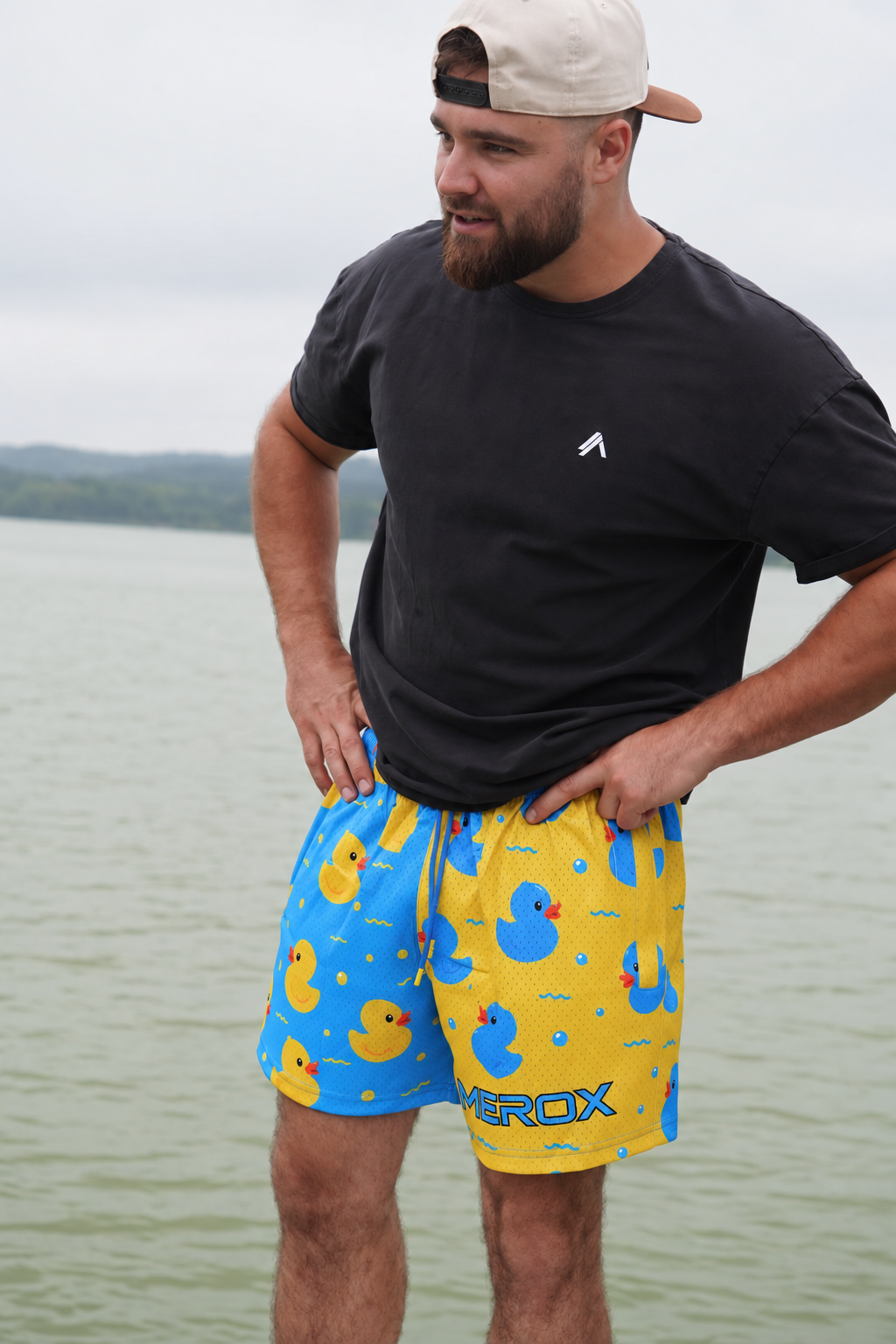 Full lifestyle view of a man wearing MEROX rubber duck mesh shorts