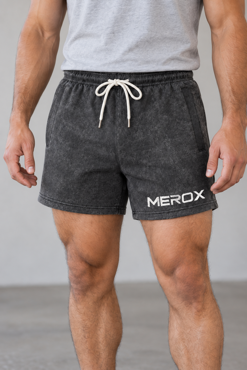 AI-generated adult male apparel visualization wearing MEROX Black Acid Wash cotton shorts; close view of the cotton wash, covered pockets, white drawstring and white MEROX logo.