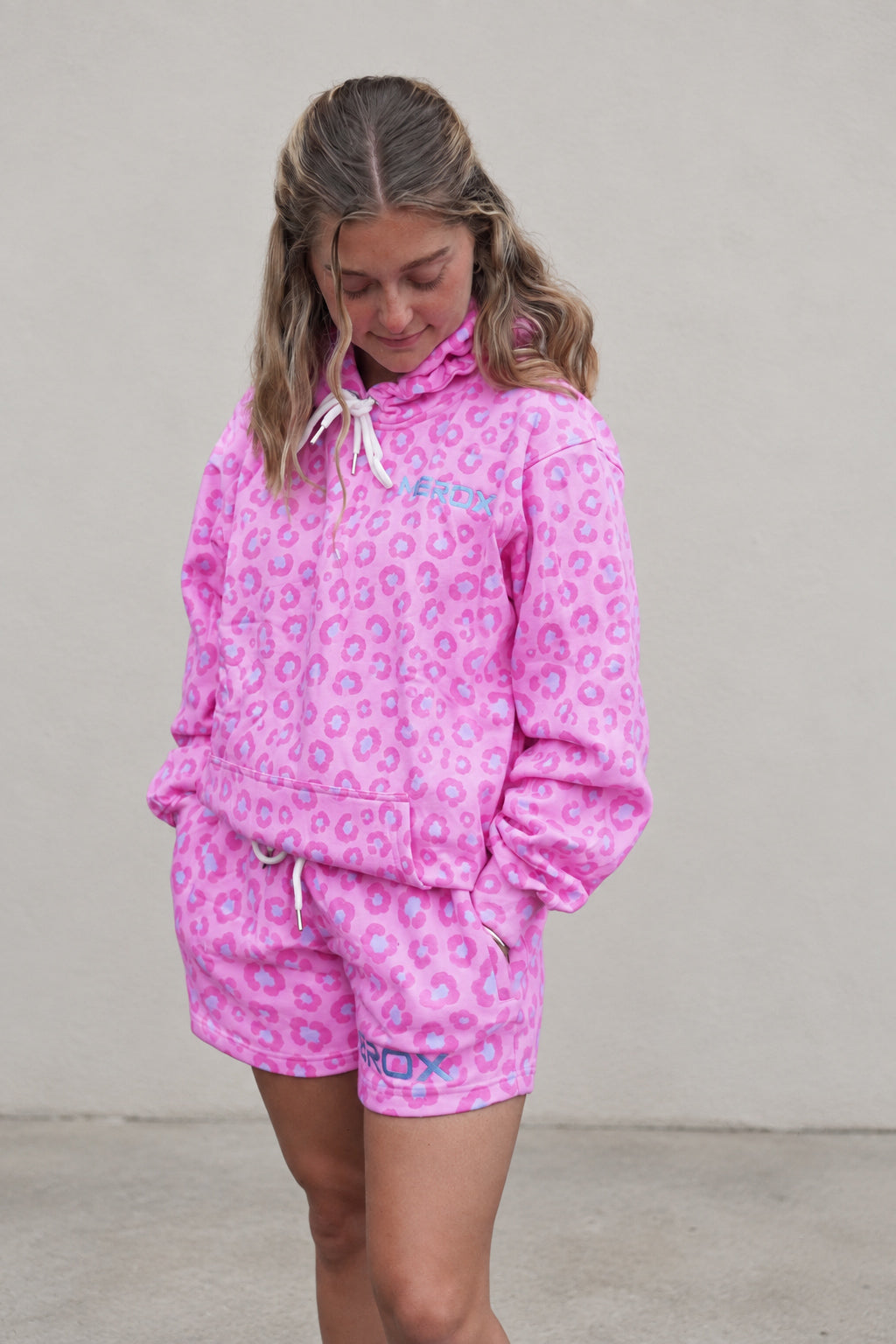 Woman wearing MEROX pink leopard hoodie with matching shorts